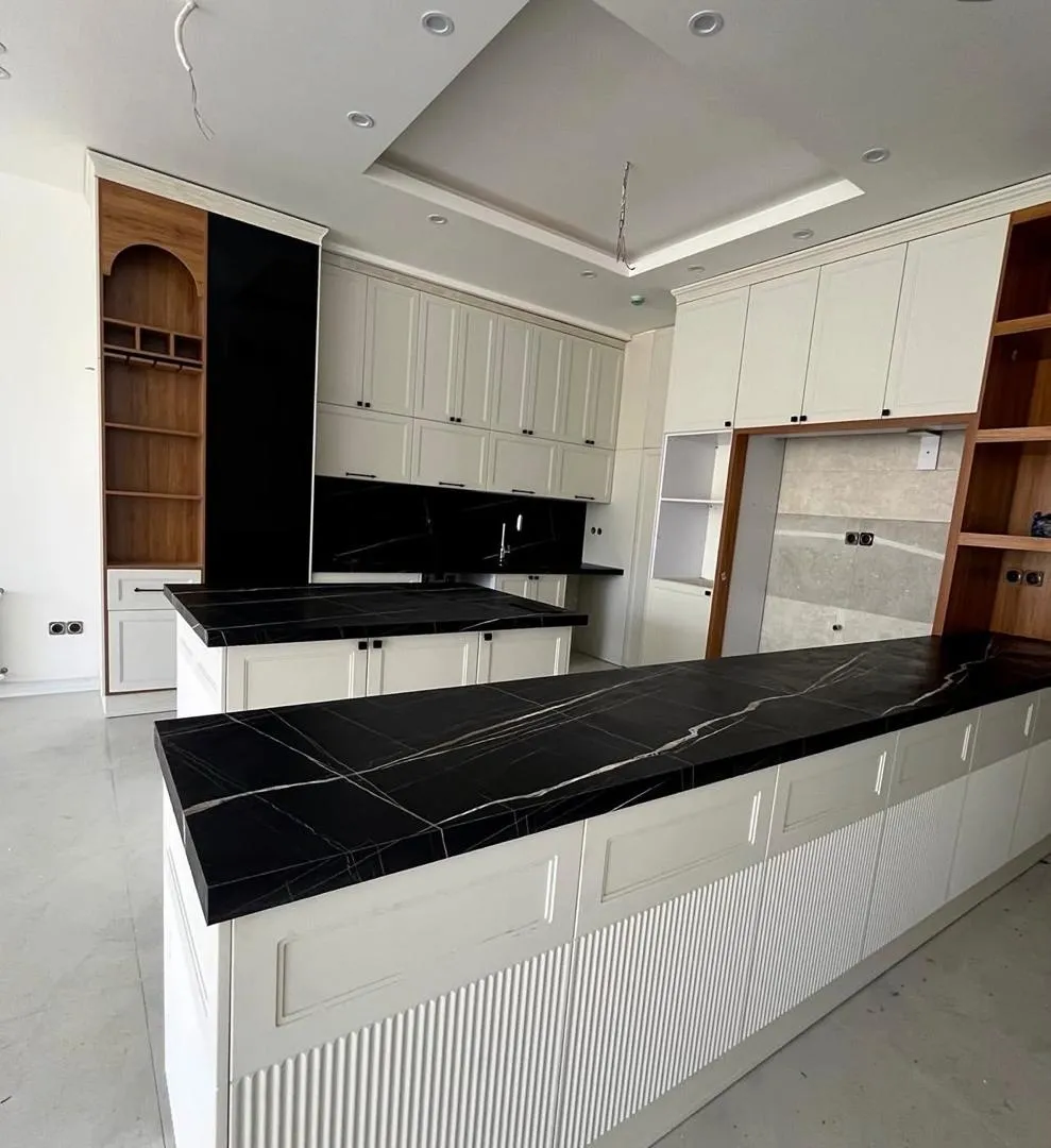 صفحه کابینت کوارتز مشکی رگه‌دار روی جزیره‌ی آشپزخانه